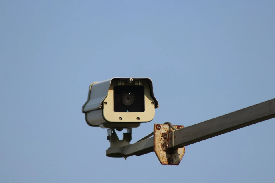 Security camera mounted on a pole against a clear sky