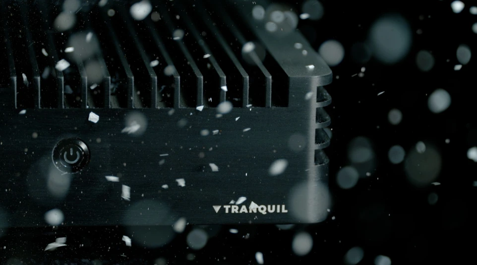 Close-up of a rugged black Tranquil edge computer chassis with a power button, displaying resilience against dust and flying debris.